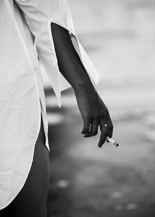 – Mustavalkoinen valokuva tytöstä, joka pitelee savuketta veden äärellä.