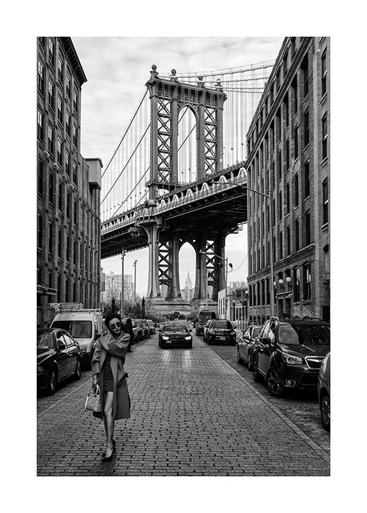  – Mustavalkoinen valokuva naisesta, joka seisoo kadulla New Yorkissa Manhattan Bridgen edessä