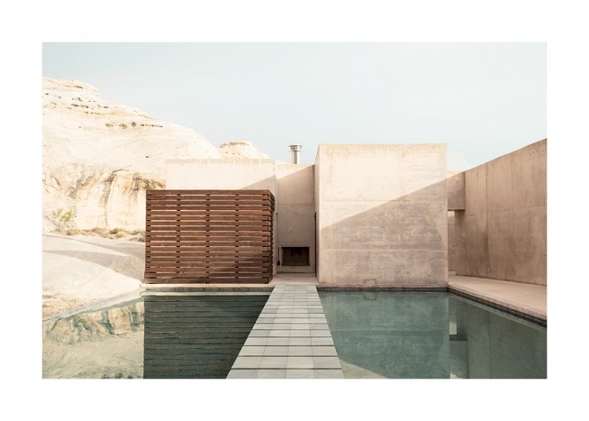 – Valokuva betonirakennuksesta vuoret taustanaan ja uima-allas edessään