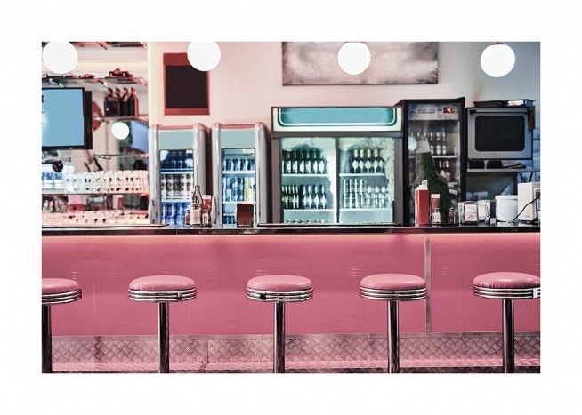  - Valokuva vintageravintolasta ja pinkeistä baarijakkaroista pinkin baaritiskin edessä