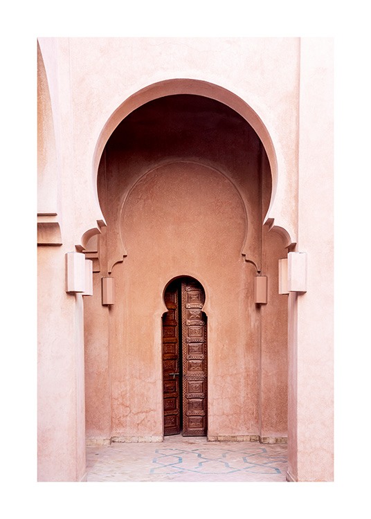  - Valokuva vaaleanpunaisesta rakennuksesta, jossa on kaarevat kaaret ja keskellä kapea, ruskea ovi