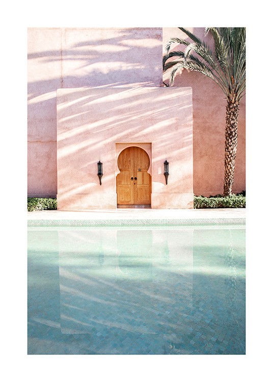  - Valokuva palmusta, vieressä vaaleanpunainen rakennus uima-altaineen