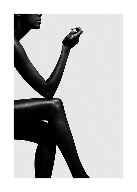  – Mustavalkoinen valokuva kyynärpää vasten ristittyjä jalkoja istuvasta naisesta