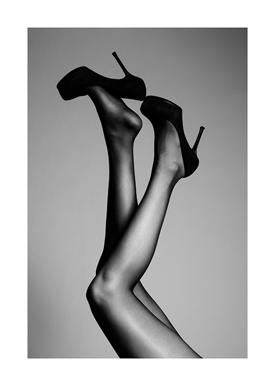  – Mustavalkoinen valokuva ilmaan ojennetuista jaloista korkokengissä