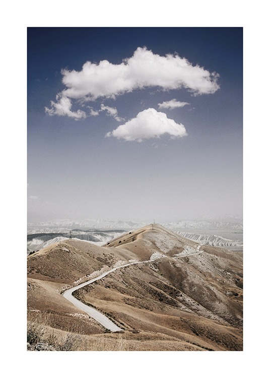  – Valokuva vuorenharjanteesta ja sen läpi vievästä tiestä pilvet ja sininen taivas taustanaan