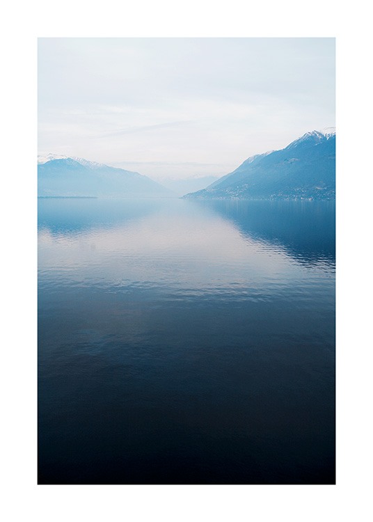  – Valokuva tyynestä järvestä taustallaan vuoria ja sumua