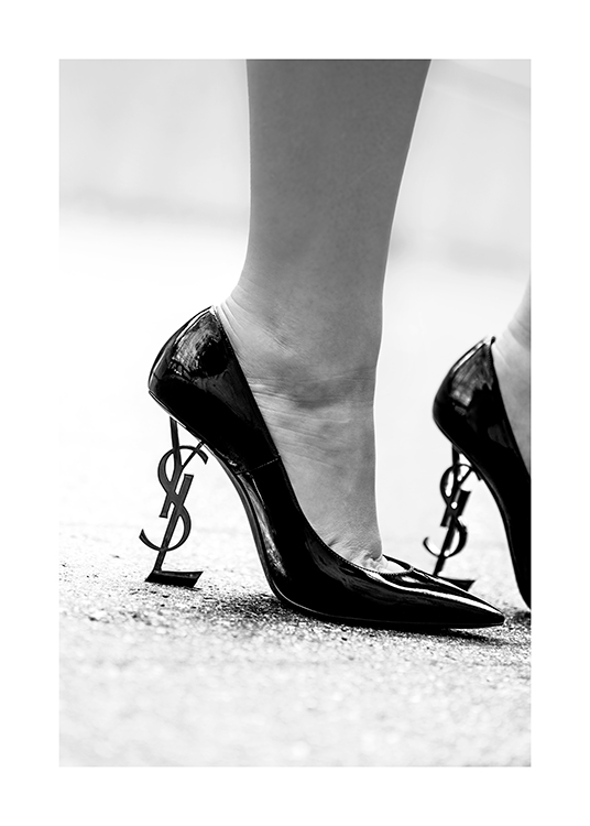 – Mustavalkoinen valokuva parista korkokantaisia kenkiä YSL-logot kantoinaan