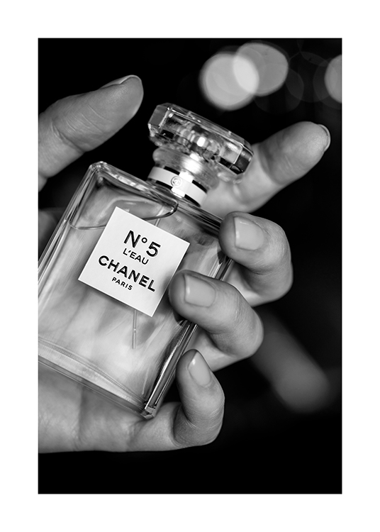  – Mustavalkoinen valokuva Chanel No5 -parfyymipulloa pitelevästä kädestä