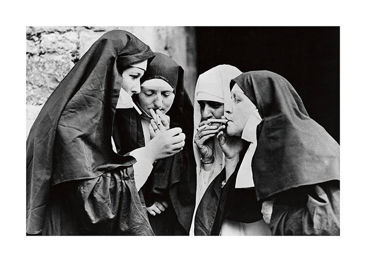  – Mustavalkoinen valokuva nunnista tupakoimassa ryhmässä