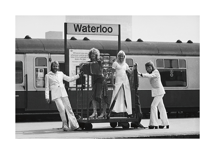  – Mustavalkoinen valokuva Waterloon rautatieasemalla seisovista ABBA-yhtyeen jäsenistä