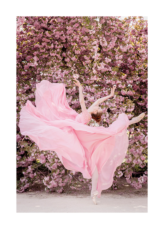  – Valokuva ballerinasta vaaleanpunaisessa mekossa tanssimassa vaaleanpunaisen kukkaseinän edessä