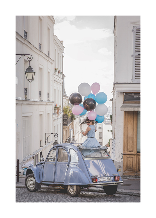  – Valokuva ilmapalloja pitelevästä naisesta sinisessä vintage-autossa