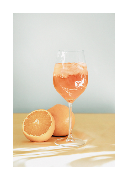  – Valokuva aperol spritzistä viinilasissa, jonka vieressä appelsiineja