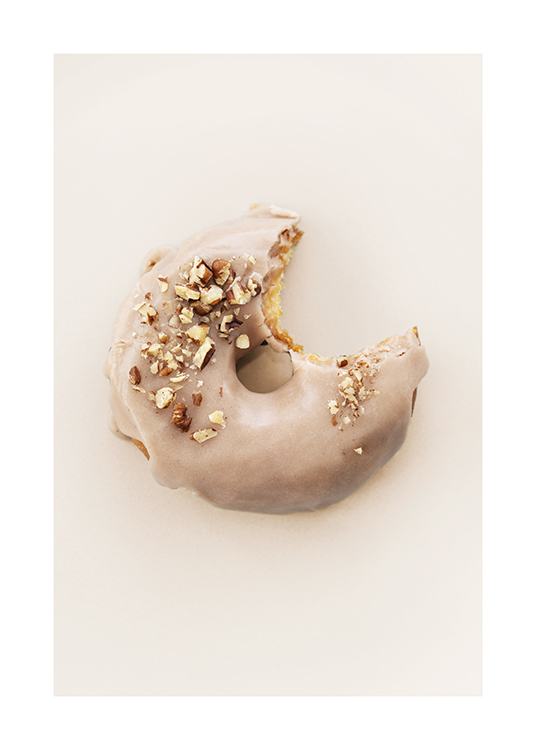  – Valokuva donitsista, jossa beige kuorrutus ja pähkinärouhetta