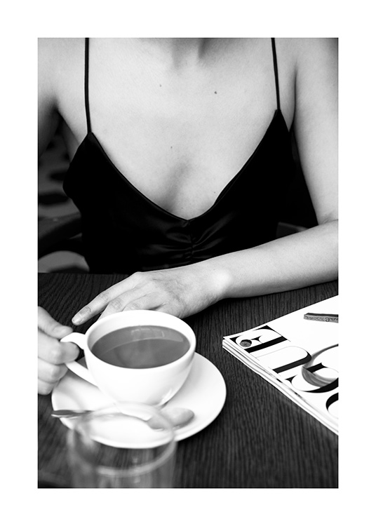  – Mustavalkoinen valokuva naisesta kahvilassa ja kahvikupista pöydällä