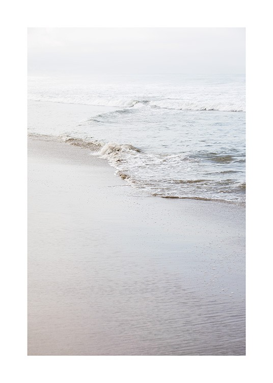  - Valokuva rannasta ja tyynestä rantaviivasta mataline aaltoineen